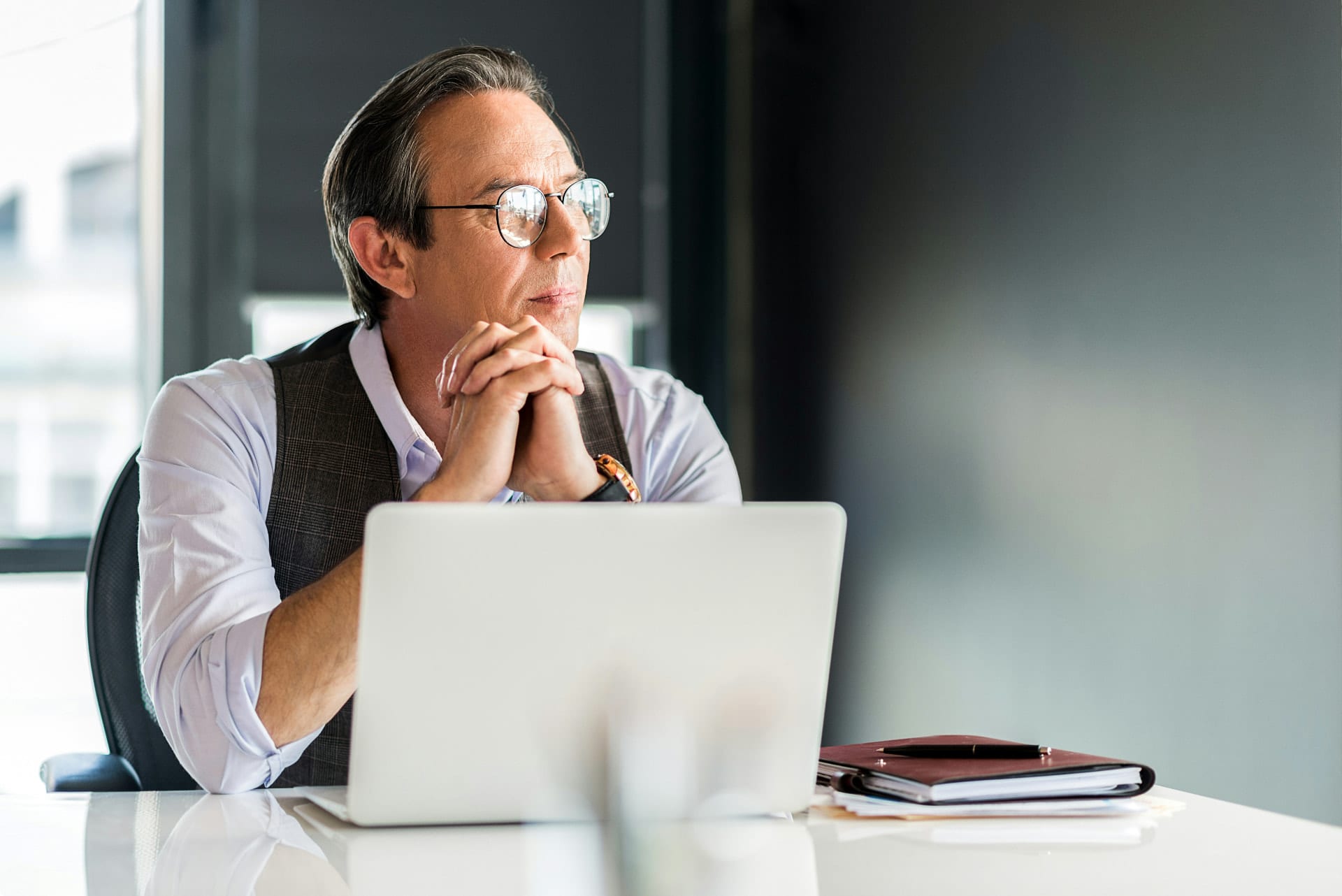 Avocat en réflexion devant son ordinateur portable dans son cabinet
